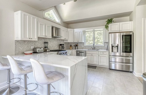Northwest Harbor House | Modern, coastal-style home with flooding natural light, a private pool, a.