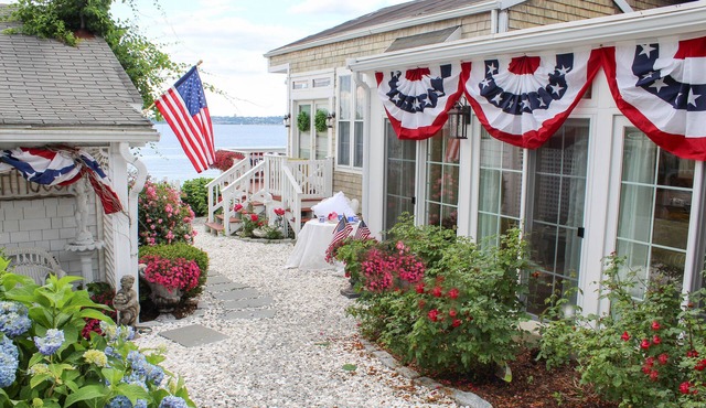 Old fashioned designer front porch living by the sea with expansive water views.